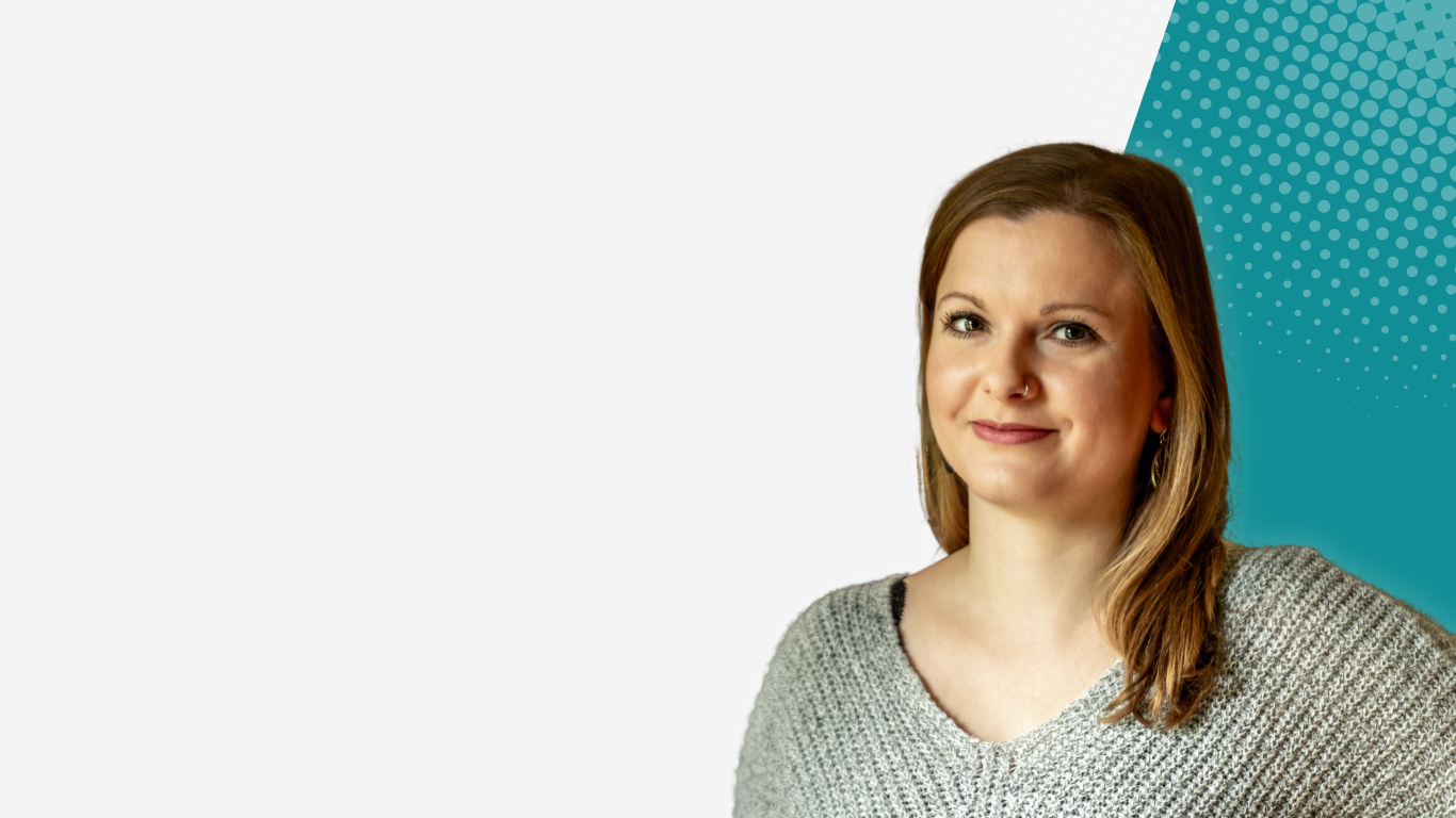 Die lächelnde Interim Executive Assistenz Corinna aus Hamburg im grauen Pullover vor einem neutralen Hintergrund